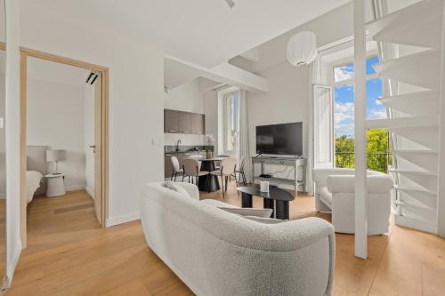 un salon avec un canapé et une table dans l'établissement LB Vacation Rentals I Beautiful, Renovated Duplex with Swimming Pool, à Cannes