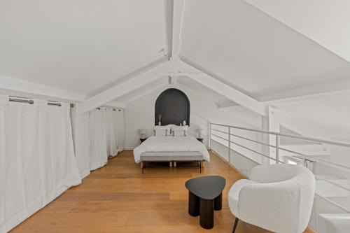 - une chambre blanche avec un lit et deux chaises dans l'établissement LB Vacation Rentals I Beautiful, Renovated Duplex with Swimming Pool, à Cannes