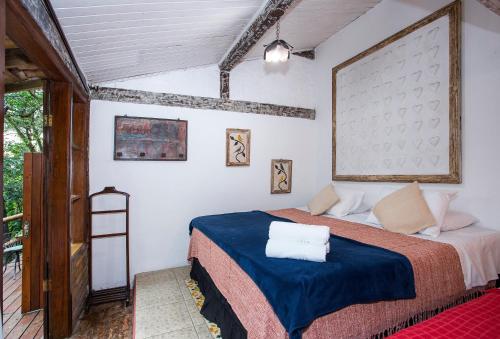 a bedroom with a bed with a blue blanket at Pousada Encanto das Águas in Ilhabela