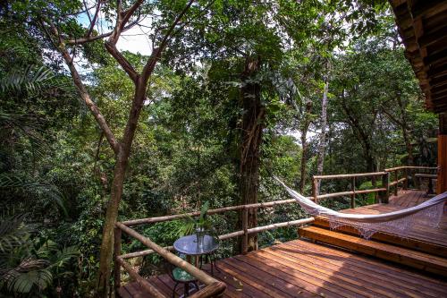 a hammock on a wooden deck in the woods at Pousada Encanto das Águas in Ilhabela