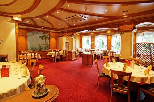 Un comedor con mesas y sillas blancas. en Hotel Zum Hackstück, en Hattingen