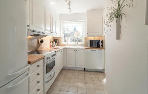 a white kitchen with white cabinets and a window at 1 Bedroom Amazing Home In Köpingsvik in Köpingsvik