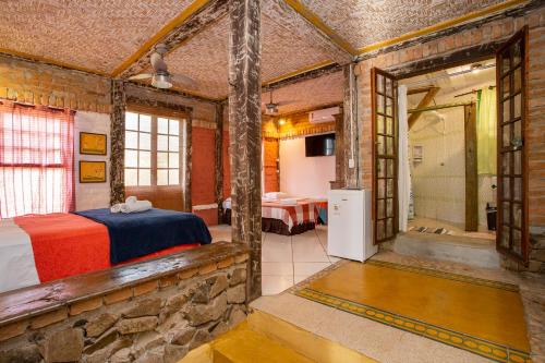 a bedroom with a bed and a bathroom with a shower at Pousada Encanto das Águas in Ilhabela