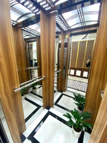 an elevator lobby with wooden columns and potted plants at Hanoian Hotel in Hà Ðông