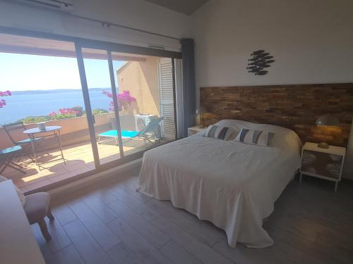 une chambre avec un lit et une vue sur l'océan dans l'établissement Appartement 3/4 pièces avec piscine, clim, wifi et parking à Sainte-Maxime - FR-1-780-23, à Sainte-Maxime