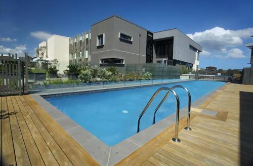 a swimming pool on the roof of a house at Azure Bliss - Majestic Apartment on the Water in Safety Beach