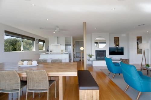 a dining room and living room with a table and chairs at Anchor Beachfront - Pet Friendly on the Beach in Frankston