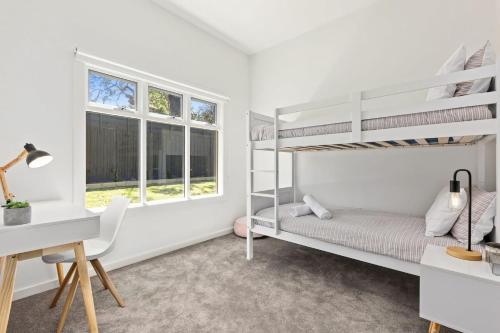 a bedroom with two bunk beds and a desk at North Haven family beach retreat in Mount Martha