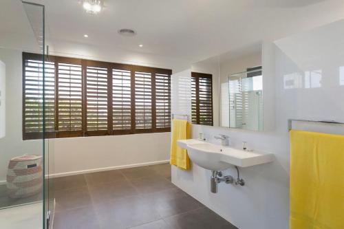 a bathroom with a sink and a glass shower at Anchor Beachfront - Pet Friendly on the Beach in Frankston
