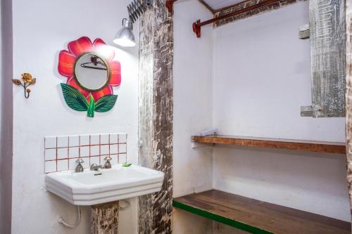 a bathroom with a sink and a clock on the wall at Pousada Encanto das Águas in Ilhabela
