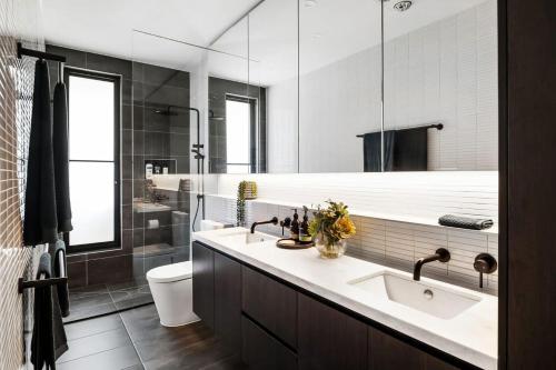 a bathroom with two sinks and a large mirror at Studio One - Luxe Apartment, across from beach, walk to local shops in Mount Martha
