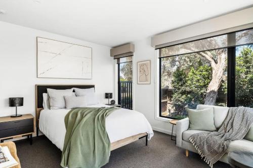 a bedroom with a bed and a chair and a window at Studio One - Luxe Apartment, across from beach, walk to local shops in Mount Martha