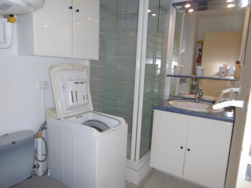 une salle de bain avec une machine à laver et un lavabo dans l'établissement **Gruissan : T2 cosy avec piscine, parking privé, proche plage et commerces** - FR-1-796-8, à Gruissan