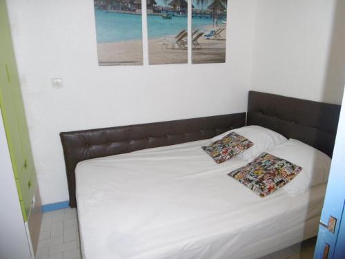 un lit avec deux oreillers dessus dans une chambre dans l'établissement Gruissan: T3, 4 Pers, Piscine, Parking, Proche Commerce, Environnement Calme, Accès Plage - FR-1-796-14, à Gruissan