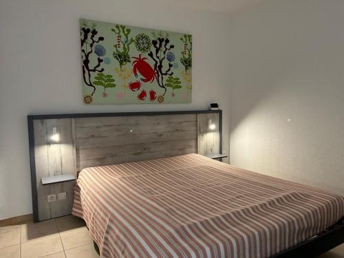 une chambre avec un lit et un tableau au mur dans l'établissement Saint-Cyprien: T3 en RDC, Terrasse, Parking, à 600m de la Plage - FR-1-793-15, à Saint-Cyprien