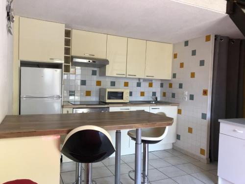 une cuisine avec des armoires blanches et un comptoir en bois dans l'établissement Villa T2 Mezzanine avec Parking, à 500m de la Plage – Saint-Cyprien - FR-1-793-16, à Saint-Cyprien
