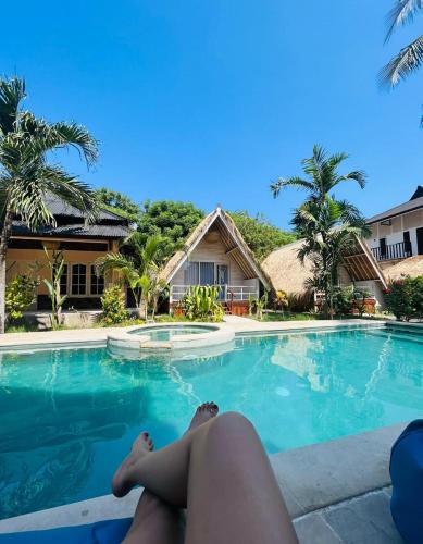 a woman laying on the edge of a swimming pool at Living Trawangan Hotel in Gili Trawangan