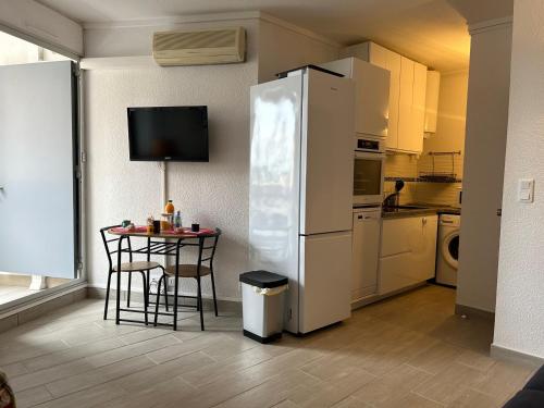 Il comprend une cuisine équipée d'une petite table et d'un réfrigérateur. dans l'établissement Studio Climatisé pour 2 Pers avec Loggia & Parking à 200m de la Plage à Saint-Cyprien - FR-1-793-18, à Saint-Cyprien