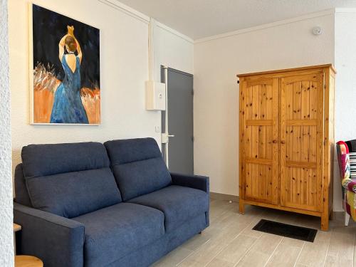 un salon avec un canapé bleu et un tableau dans l'établissement Studio Climatisé pour 2 Pers avec Loggia & Parking à 200m de la Plage à Saint-Cyprien - FR-1-793-18, à Saint-Cyprien