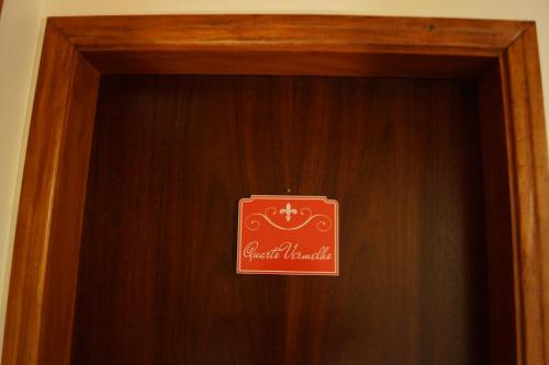 a wooden door with a sign on it at Pousada Chateau Colinas in Campos do Jordão