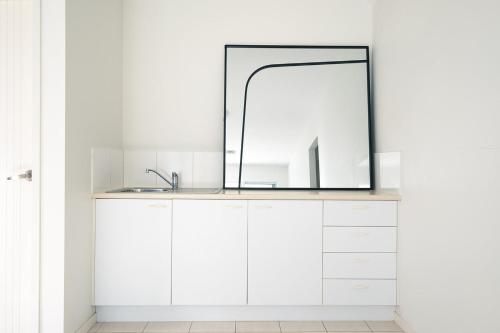 a bathroom with a sink and a mirror at Tallows House on Paterson in Byron Bay