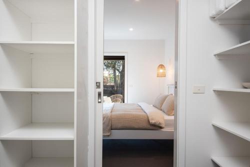 1 dormitorio con 1 cama en una habitación con estanterías en Missy's Escape - Luxe Family Entertainer Pool Spa Walk to Beach, en Mornington
