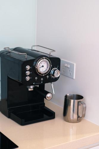 a coffee maker sitting on a counter next to a cup at Tallows House on Paterson in Byron Bay