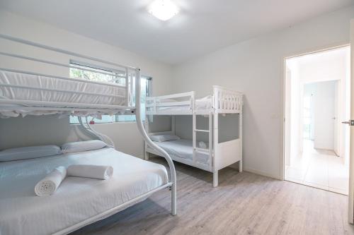 a bedroom with two bunk beds and a window at Tallows House on Paterson in Byron Bay