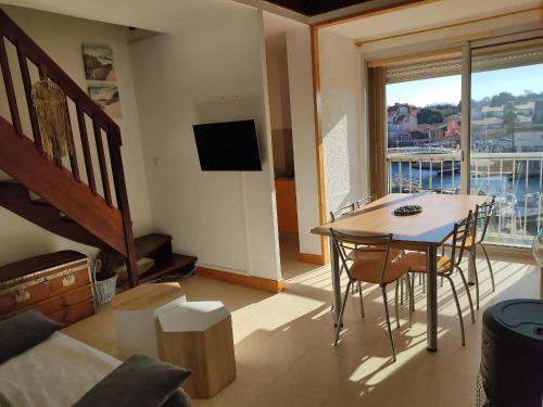 un salon avec une table et des chaises et un balcon dans l'établissement Gruissan - Spacieux T2 Mezzanine - 6 Pers - Parking - FR-1-796-22, à Gruissan