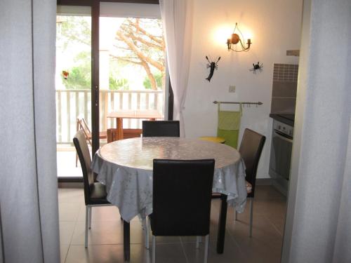 une salle à manger avec une table et des chaises et une cuisine dans l'établissement Saint Cyprien - Agréable T2 Climatisé, Parking Privé, Balcon & Solarium, 300m Plage - FR-1-793-12, à Saint-Cyprien