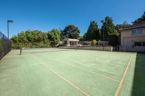a tennis court with a net on it at Vue de la Mer Luxe Retreat - Tennis, Pool, Views in Mount Martha
