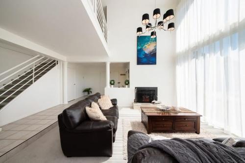 a living room with a couch and a table at Vue de la Mer Luxe Retreat - Tennis, Pool, Views in Mount Martha