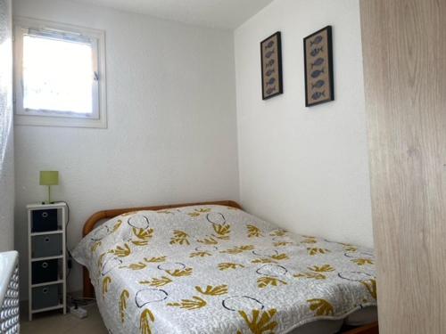 une chambre avec un lit et deux tableaux au mur dans l'établissement Joli T2 Climatisé avec Cour Privée et Parking, à 500m Plage et Port - Saint Cyprien - FR-1-793-2, à Saint-Cyprien