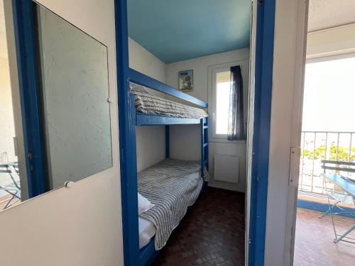 Ce lit superposé se trouve dans un dortoir doté d'un miroir. dans l'établissement Gruissan - À 2 Pas de la Plage - Studio Cabine pour 4 - Parking Sécurisé - FR-1-796-15, à Gruissan