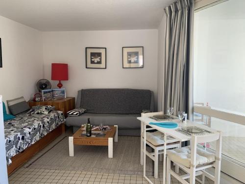 un salon avec un canapé et une table dans l'établissement T2 40m² à 150m de la plage avec parking privé et loggia - Gruissan - FR-1-796-26, à Gruissan