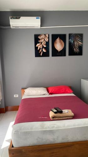 a bedroom with a bed with a red blanket at Hostal Casa Blanca in El Coca