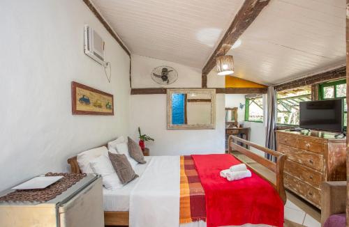 a small bedroom with a bed and a tv at Pousada Encanto das Águas in Ilhabela