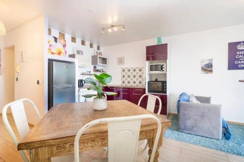 a kitchen and dining room with a wooden table and chairs at Sunset Beach Residence - Studio on the beach in Punaauia