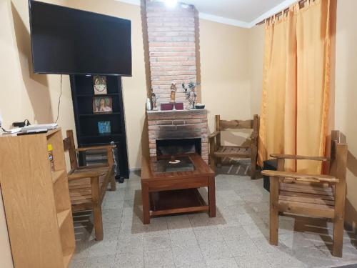 a living room with a fireplace and a flat screen tv at Casa Martina in Tinogasta