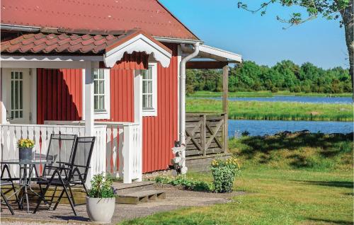 a red and white house with a table and chairs at Amazing Home In Fågelmara With Wifi in Fågelmara