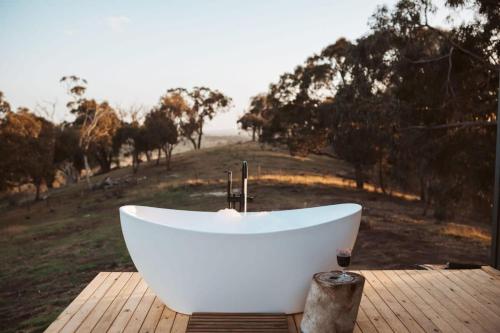 a white bath tub sitting on a wooden deck at Tiny Ikigai in Wallan