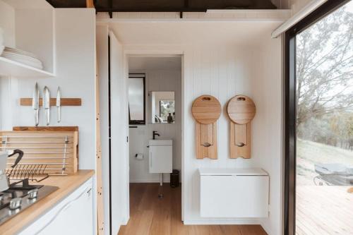 a kitchen with wooden cutting boards on the wall at Tiny Ikigai in Wallan