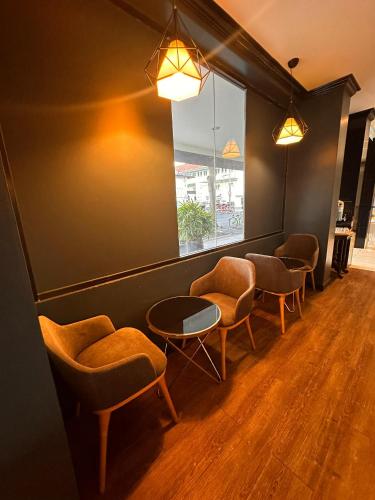 a waiting room with chairs and tables and a window at Merchant Hotel in George Town