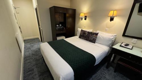 a hotel room with a large bed and a television at Trinity Hotel in Wellington