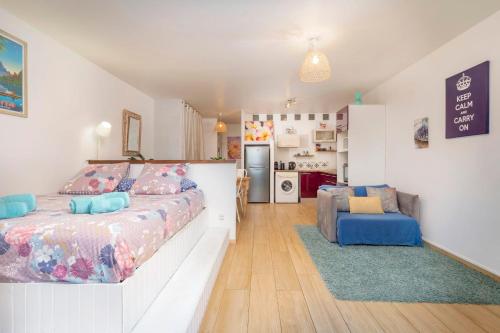 a bedroom with a large bed and a kitchen at Sunset Beach Residence - Studio on the beach in Punaauia