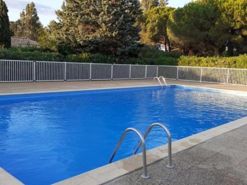 une piscine avec de l'eau bleue dans une cour dans l'établissement Villa T3 à Saint-Cyprien, 6 pers, Piscine, Terrasse, Proche Plage et Port - FR-1-793-22, à Saint-Cyprien