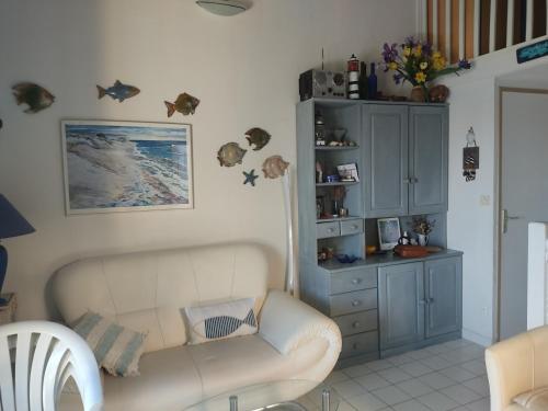 - un salon avec un canapé et une armoire dans l'établissement Villa Climatisée Bord de l'Eau - 4/5 pers - Proche Plage avec Parking Privé - FR-1-796-30, à Gruissan