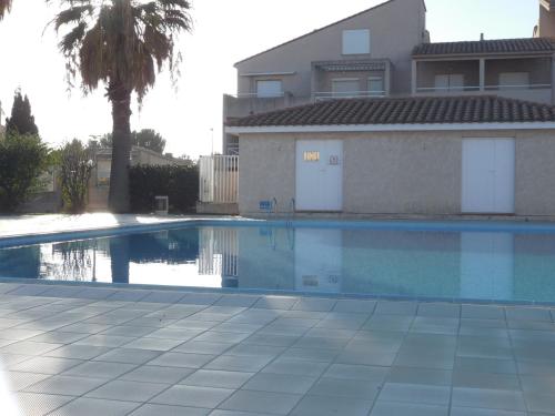 une piscine devant une maison dans l'établissement Villa T3 Mezzanine 6P - Piscine, Parking, Proche Plage et Port à Saint-Cyprien - FR-1-793-25, à Saint-Cyprien