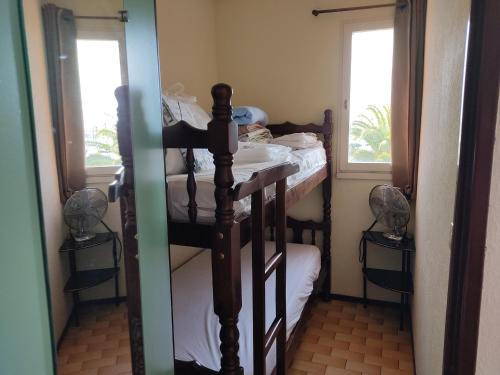 - une chambre avec des lits superposés et 2 fenêtres dans l'établissement Studio Cabine à Gruissan pour 4 pers - Parking sécurisé - FR-1-796-40, à Gruissan