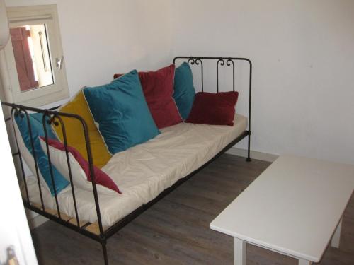 - un canapé avec des oreillers colorés dans l'établissement Villa T4 mezzanine climatisée avec parking, proche plage et port à Saint-Cyprien - FR-1-793-28, à Saint-Cyprien